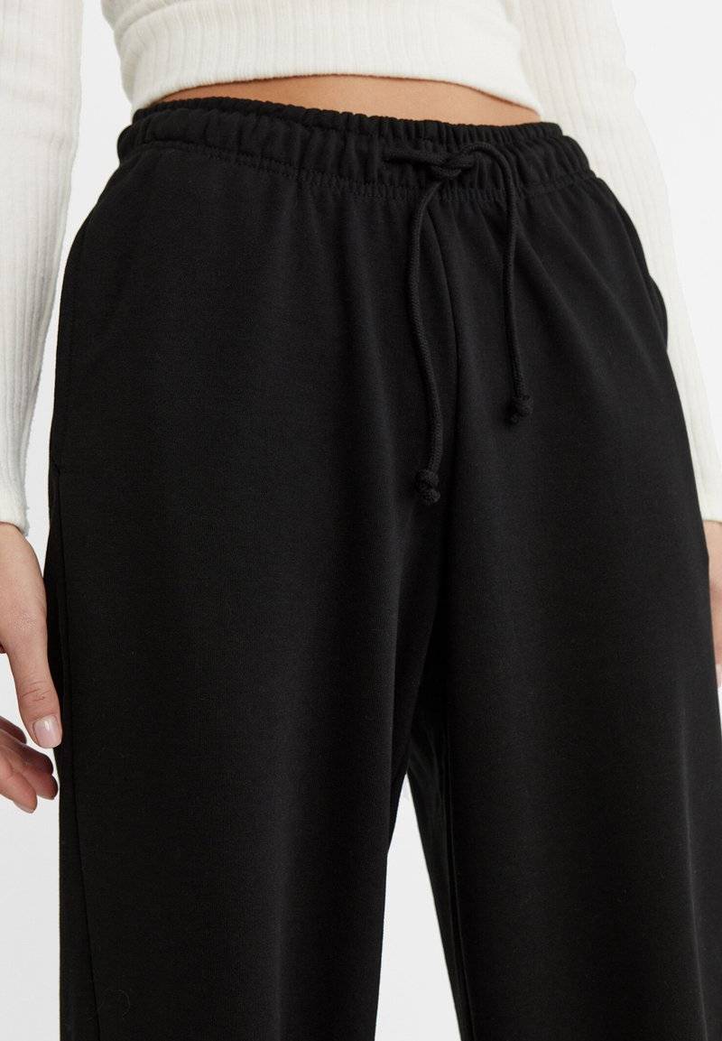 Stradivarius Stradivarius WIDE-LEG JOGGER - Tracksuit bottoms - black Nur noch ein Tag übrig