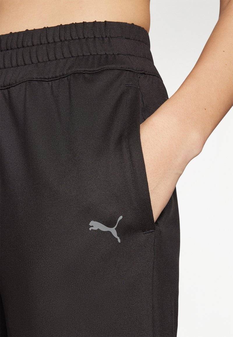 Puma Puma STUDIO FOUNDATIONS - Tracksuit bottoms - black Begrenzt auf 3 Tage